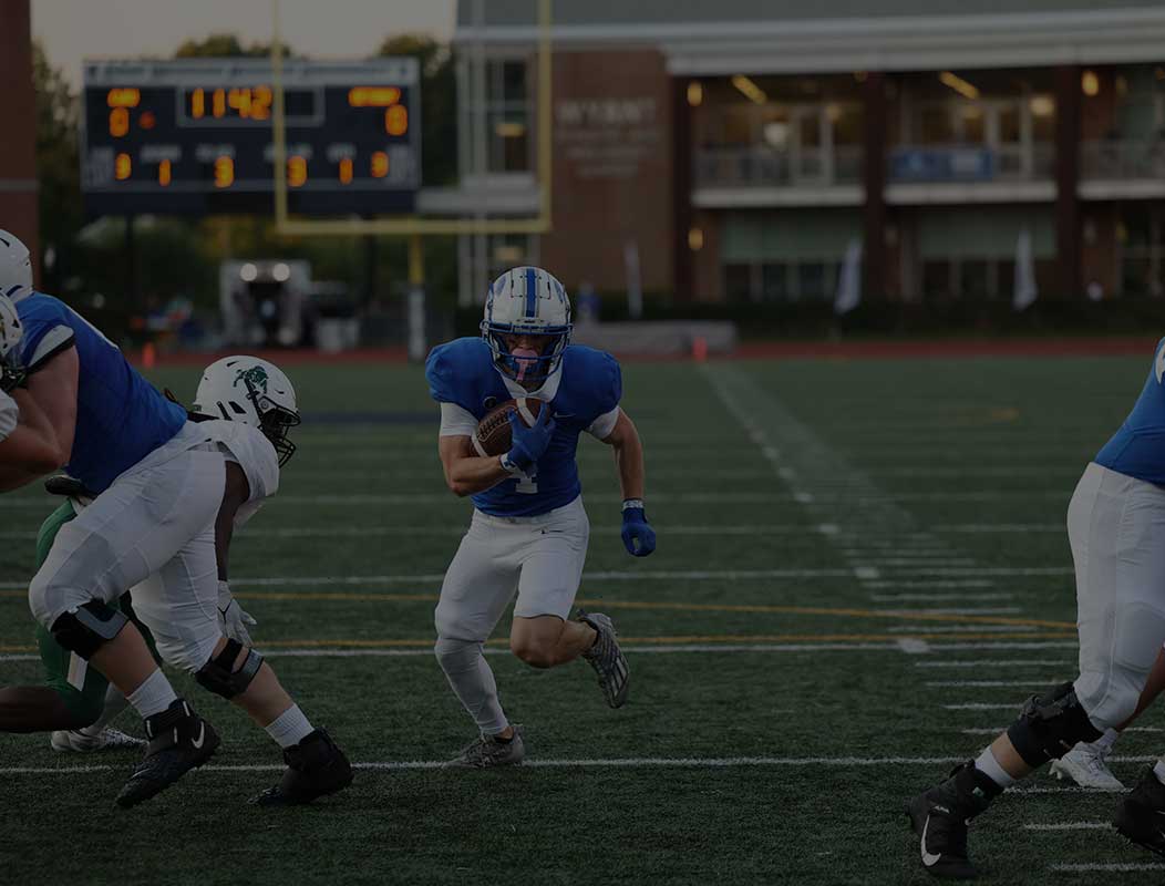CWRU football player running down the field in between defenders