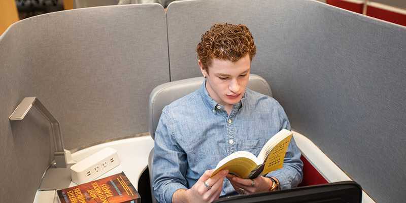Photo of a Case Western Reserve University student reading in a cubicle