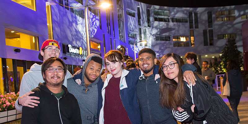 Photo of a group of Case Western Reserve University students huddled together, posing, in Uptown Cleveland